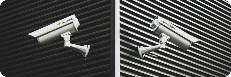 deux caméras de surveillance sur un mur en bardage noir
