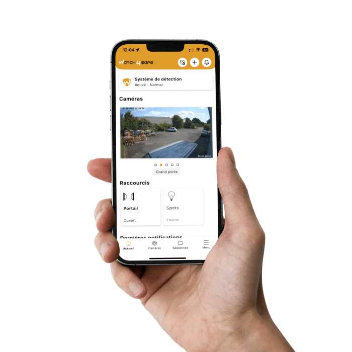 Main tenant un smartphone affichant l’application Watch4Safe, permettant de surveiller les caméras, gérer un portail motorisé et contrôler des équipements comme l’éclairage.